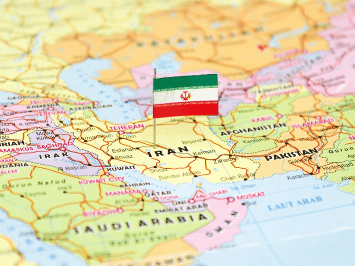 A world map of the middle east with the Iranian flag pinned on Iran.